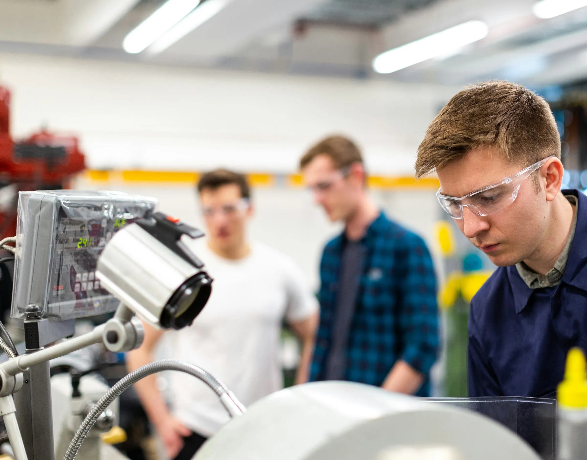 Auszubildende bei der Arbeit an Metall